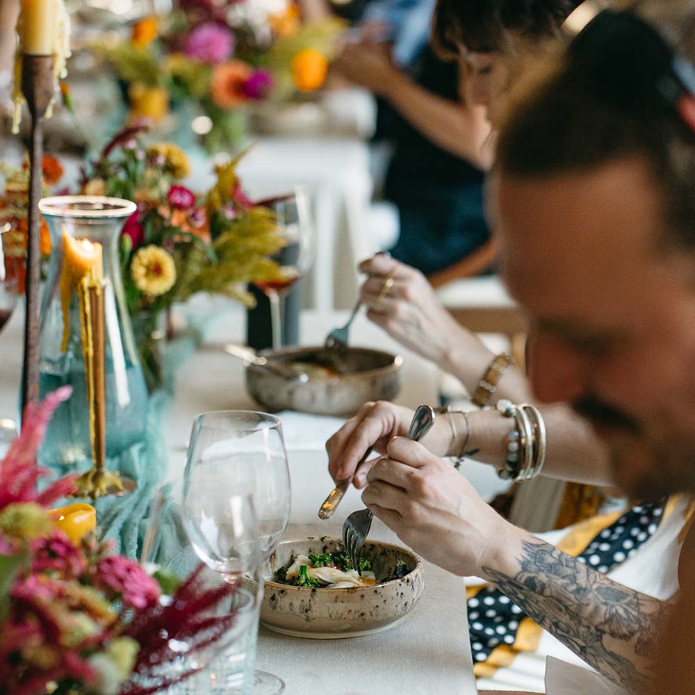 People dining at a table with floral decorations and candles